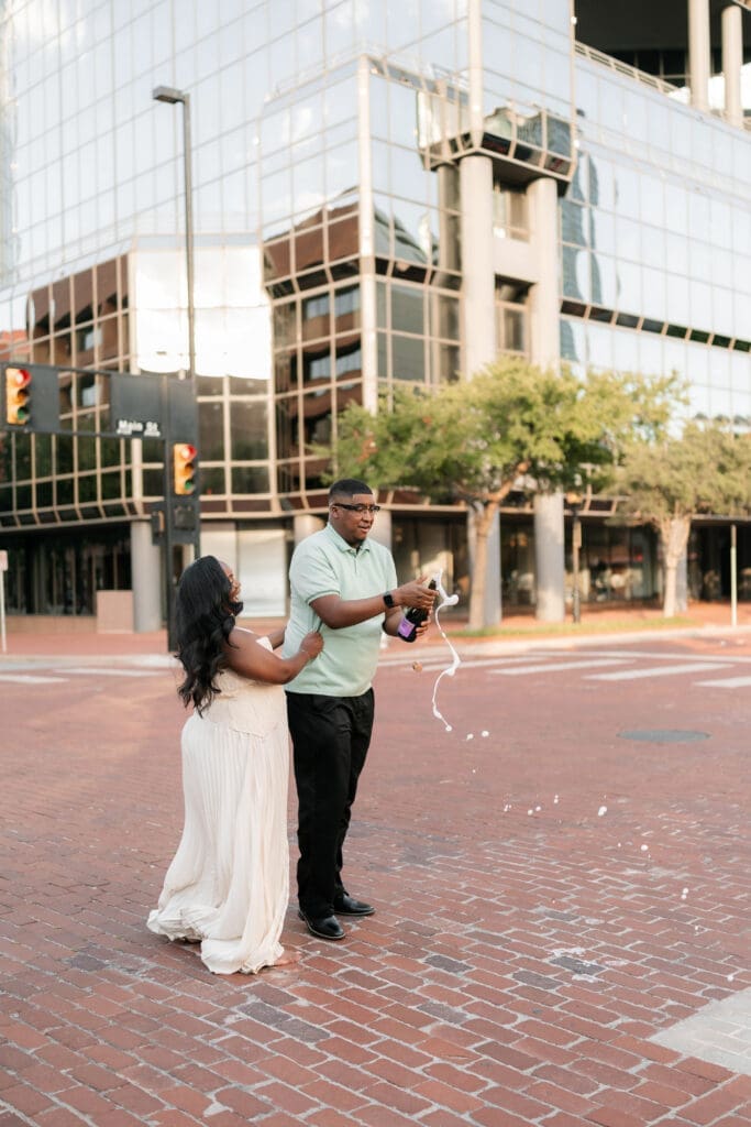 Engaged couple popping prosecco in downtown Fort Worth
