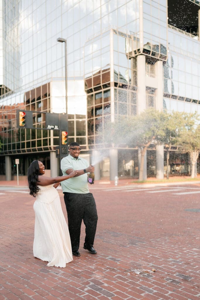 Engaged couple popping prosecco in downtown Fort Worth