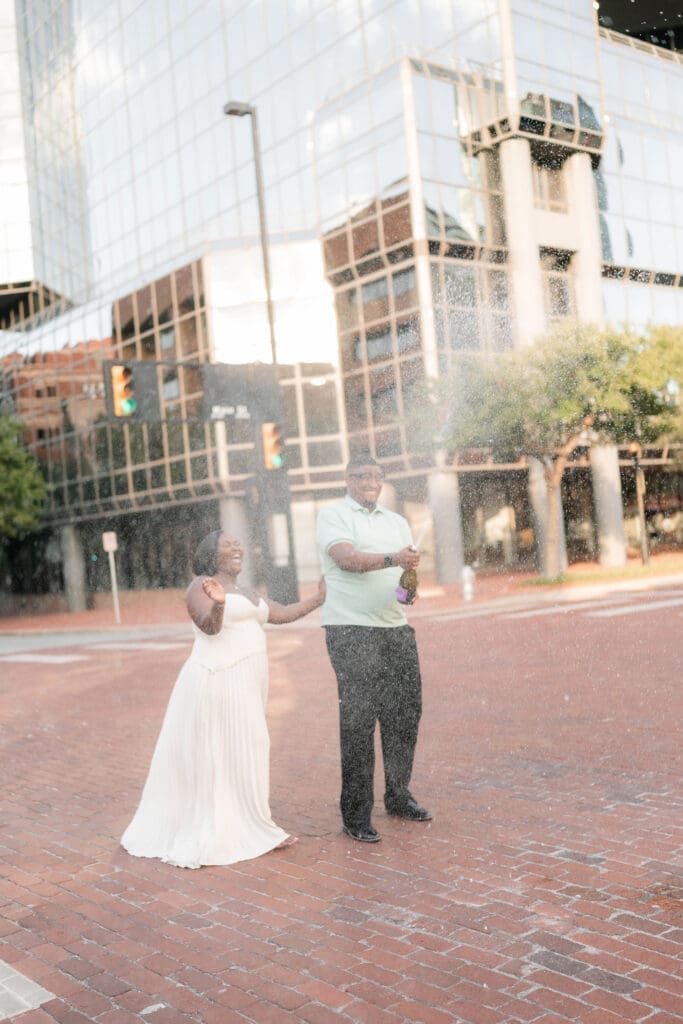 Engaged couple popping prosecco in downtown Fort Worth