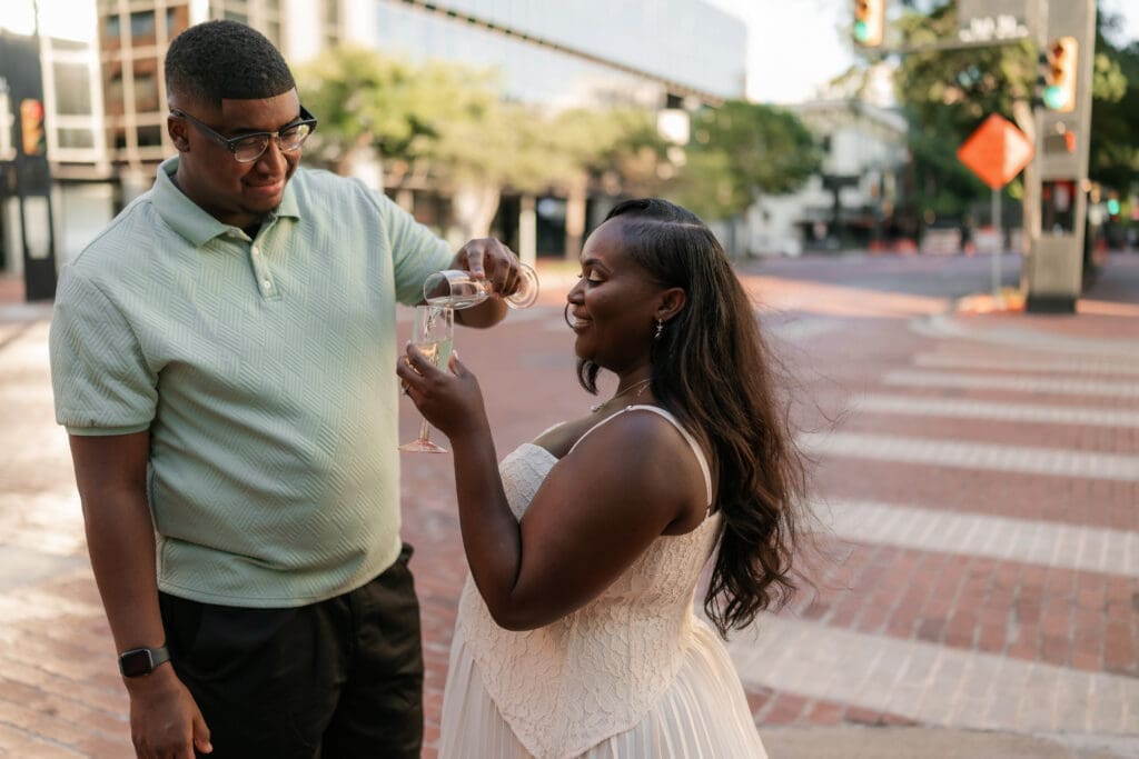 Engaged couple popping prosecco in downtown Fort Worth