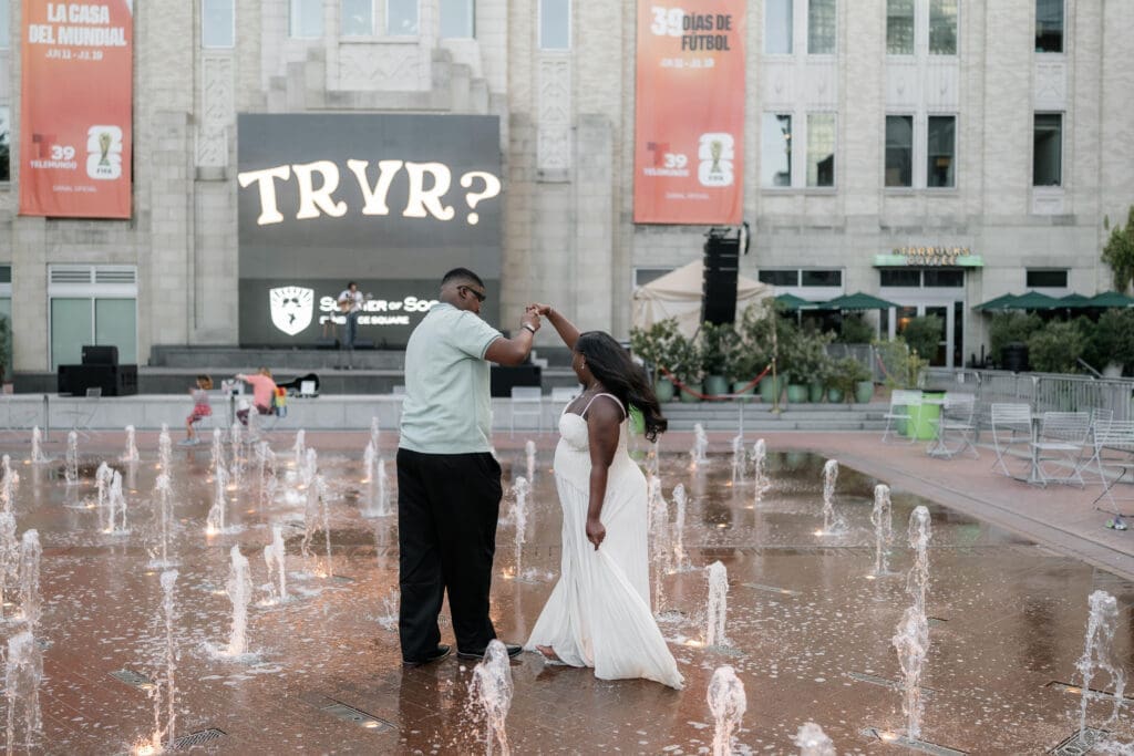 Couple dancing in the water fountain in Sundance Square