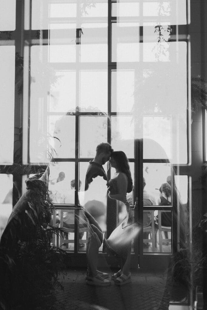 Black and white double exposure shot of man and woman embracing in the Sundance Pavilion in Sundance Square, Fort Worth