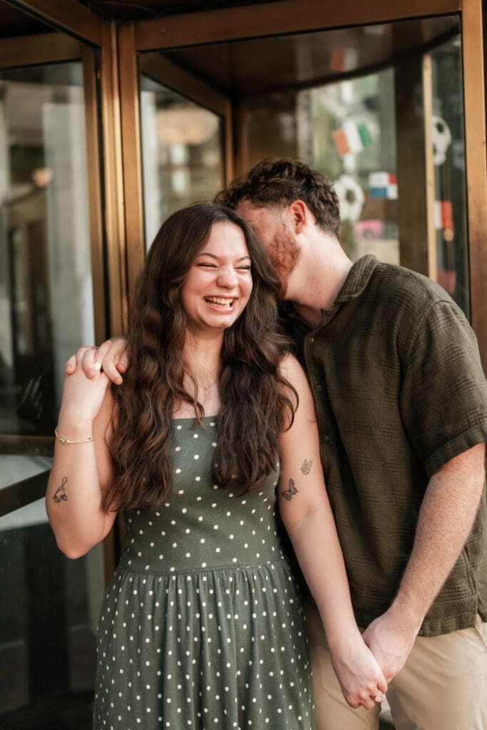 Man and woman embracing in a doorway in Sundance Square, Fort Worth, TX during their engagement photo session