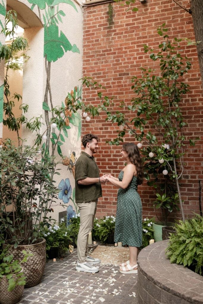 Man and woman holding hands in Sundance Alley during their engagement photo session in Fort Worth, TX