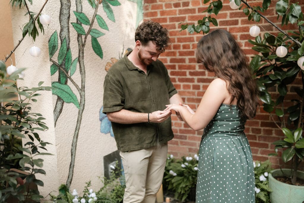 Man putting the ring on his fiance's finger in Sundance Alley in Sundance Square, Fort Worht, TX