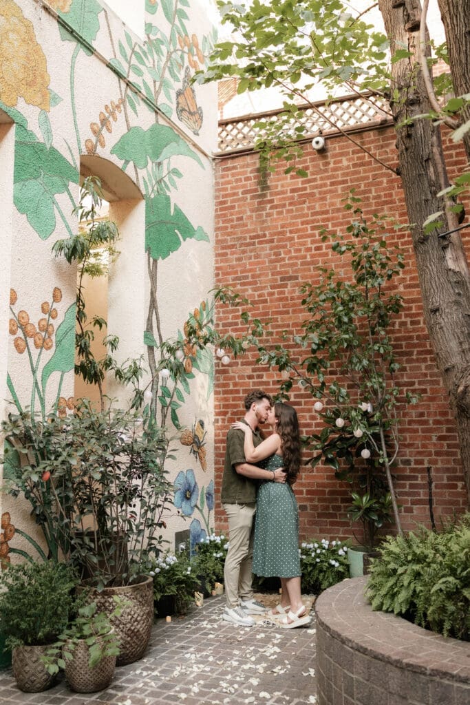 Man and woman embracing and kissing after he proposed to her in Sundance Alley in Sundance Square, Fort Worth, TX