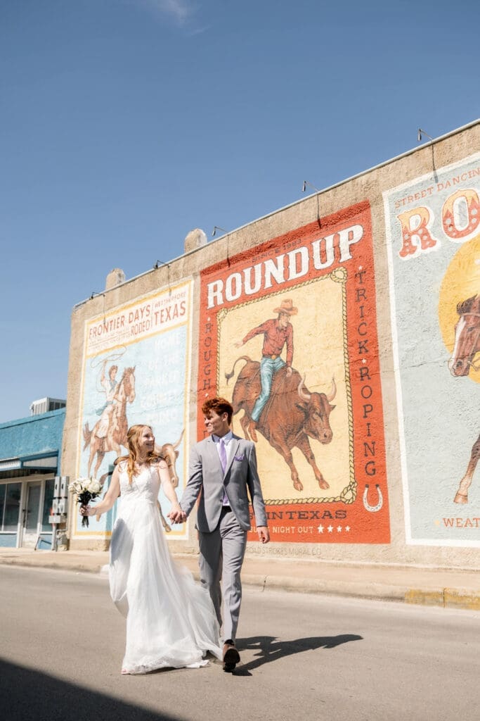 Bride and groom running across the street in downtown Weatherford, TX 