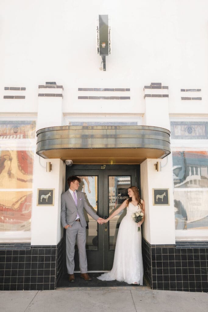 Bride and Groom embracing in front of Jazz Chapel in Downtown Weatherford, TX