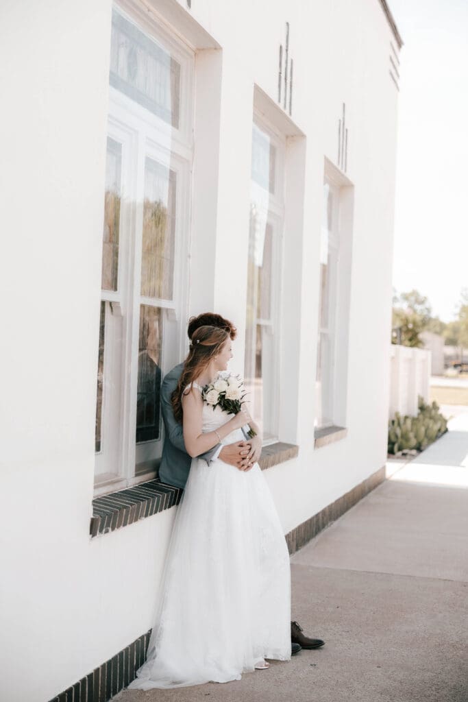 Bride and Groom embracing in front of Jazz Chapel in Downtown Weatherford, TX