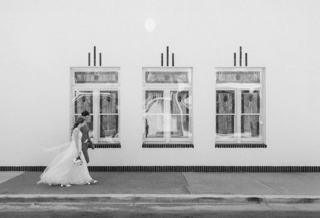 Bride and Groom walking in front of Jazz Chapel in Downtown Weatherford, TX