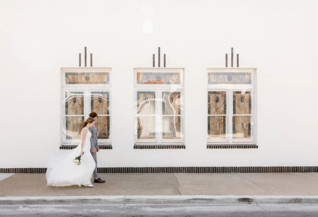 Bride and Groom walking in front of Jazz Chapel in Downtown Weatherford, TX