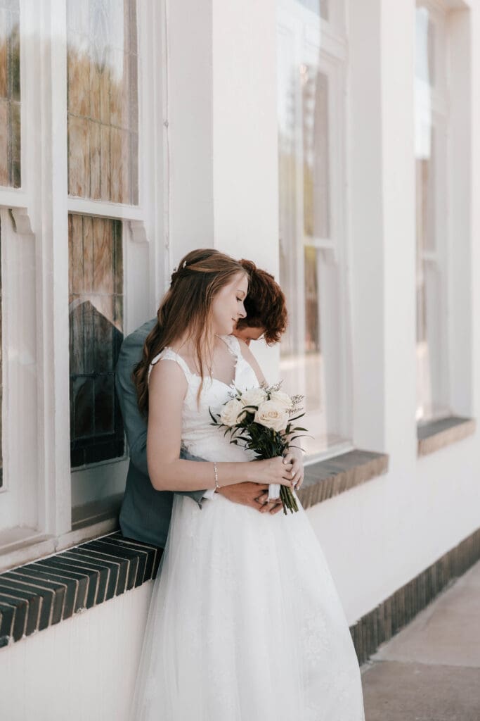 Bride and Groom embracing in front of Jazz Chapel in Downtown Weatherford, TX