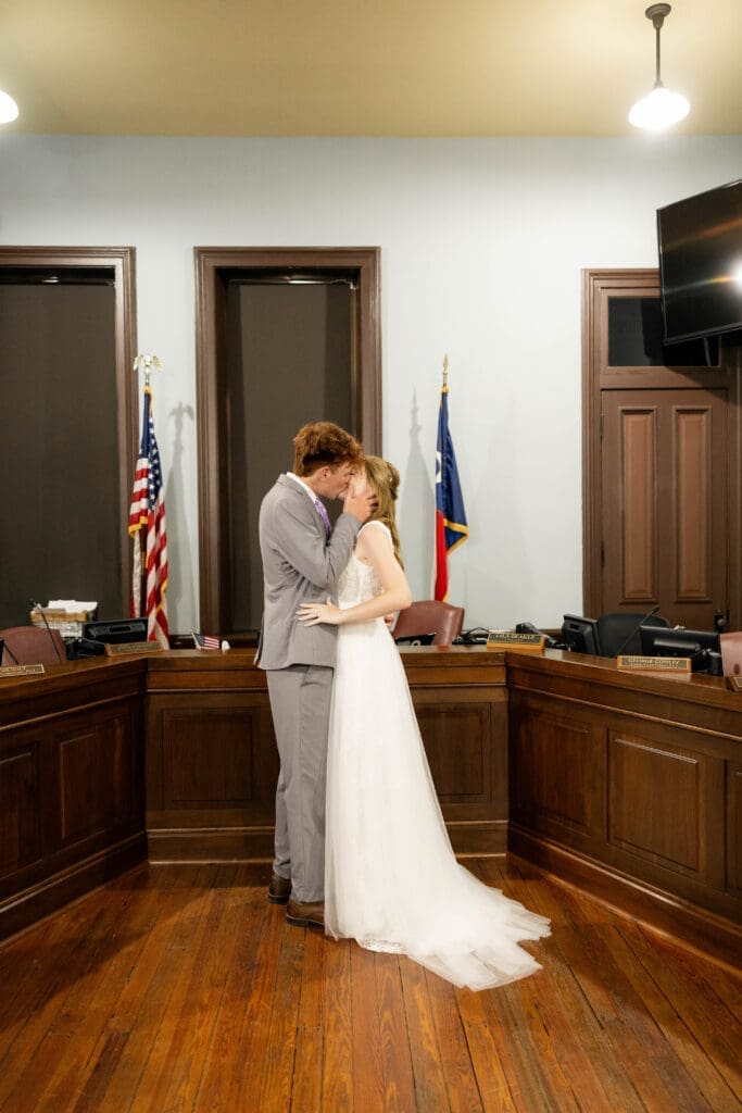 Bride and groom in courthouse courtroom kissing during their Weatherford Courthouse Wedding