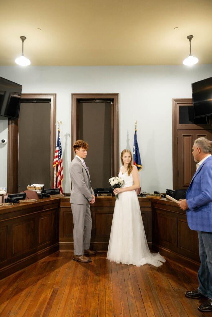 Bride and groom in courthouse courtroom with judge Pat Deen during their Weatherford Courthouse Wedding
