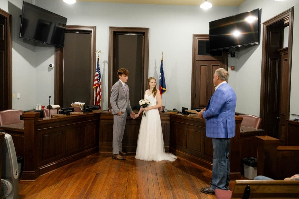 Bride and groom in courthouse courtroom with judge Pat Deen during their Weatherford Courthouse Wedding
