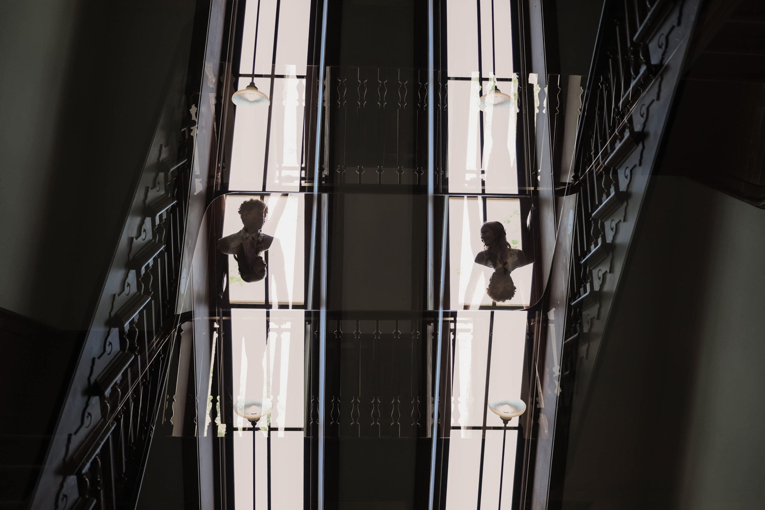 A black and white double exposure shot of bride and groom in front of windows in the Weatherford Courthouse in Weatherford, TX