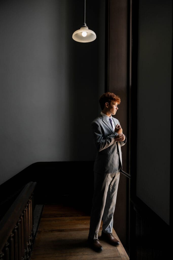 Moody shot of groom at the Weatherford Courthouse during their elopement