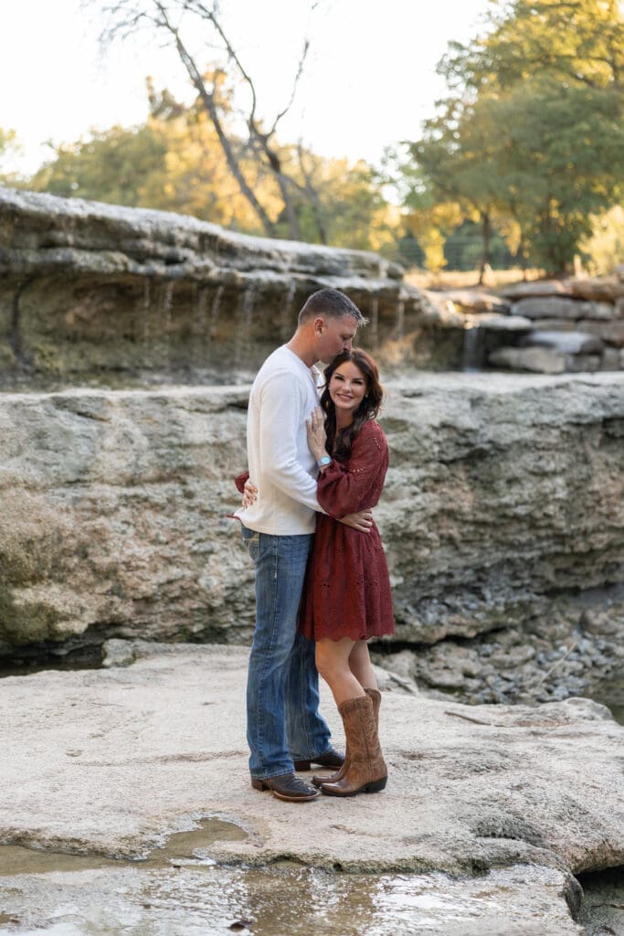 engaged couple embracing at Airfield Falls in Fort Worth