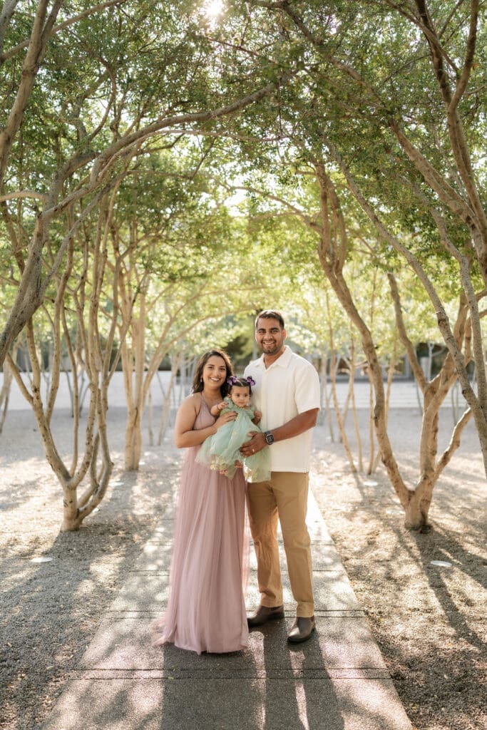 Family standing amongst the crape myrtle trees at Kimbell Art Museum during their family portrait session in Fort Worth