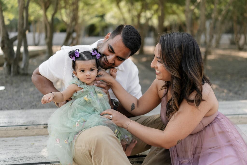 Family snuggling amongst the crape myrtle trees at Kimbell Art Museum during their family portrait session in Fort Worth
