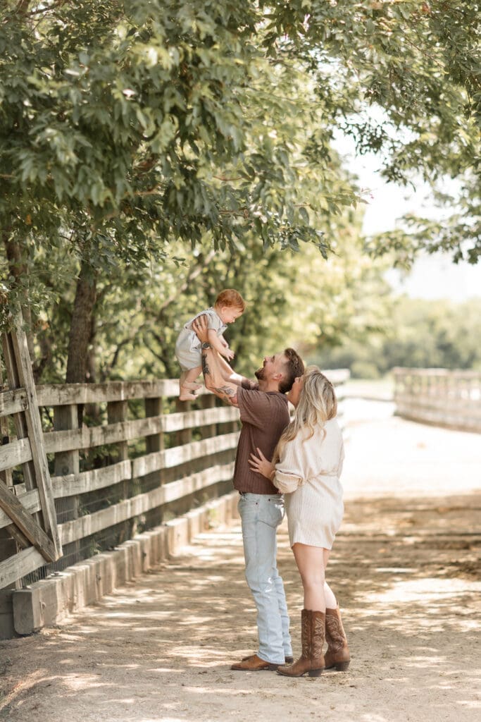 Husband and wife holding up their toddler at the Cactus Garden in Fort Worth during their family photography session