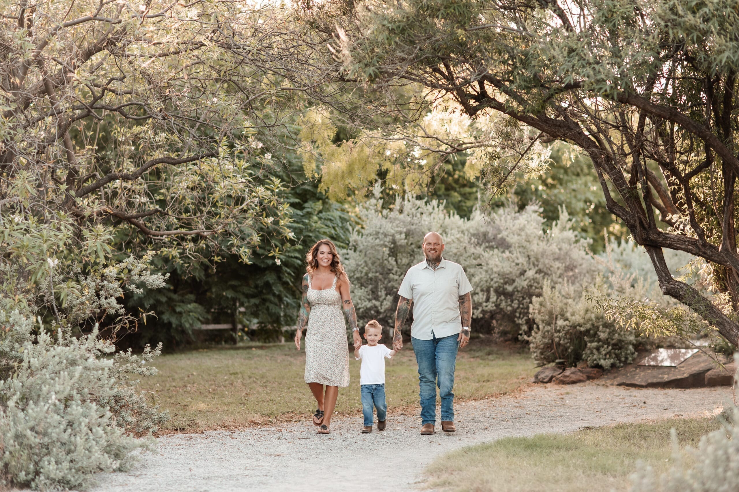 husband and wife walking with their toddler along a trail at the Cactus Garden in Fort Worth, TX