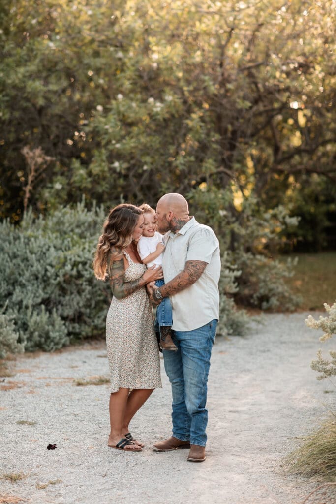 Husband and wife snuggling their toddler at the Cactus Garden in Fort Worth during their family photography session