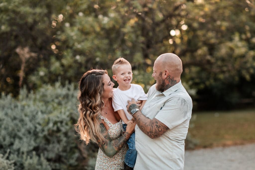 Husband and wife snuggling their toddler at the Cactus Garden in Fort Worth during their family photography session