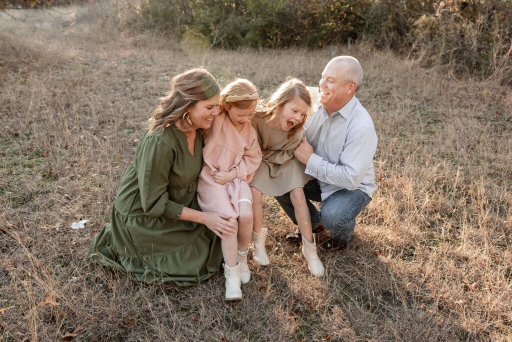 Family skipping in grass during their family photos at Soldier Spring Park in Weatherford