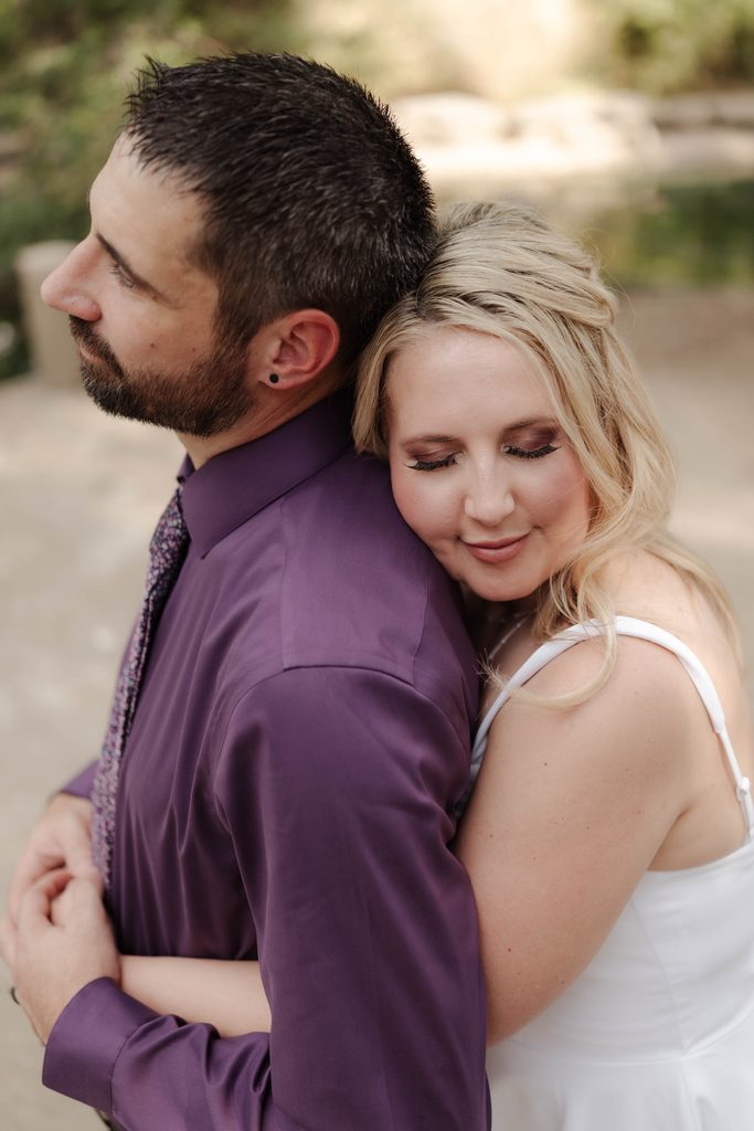 Bride and groom taking wedding portraits in front of the duck pond at Trinity Park in Fort Worth, TX