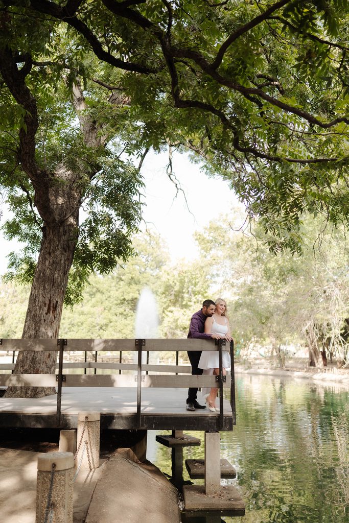 Bride and groom posing on the wood decking at the duck pond at Trinity Park in Fort Worth, TX