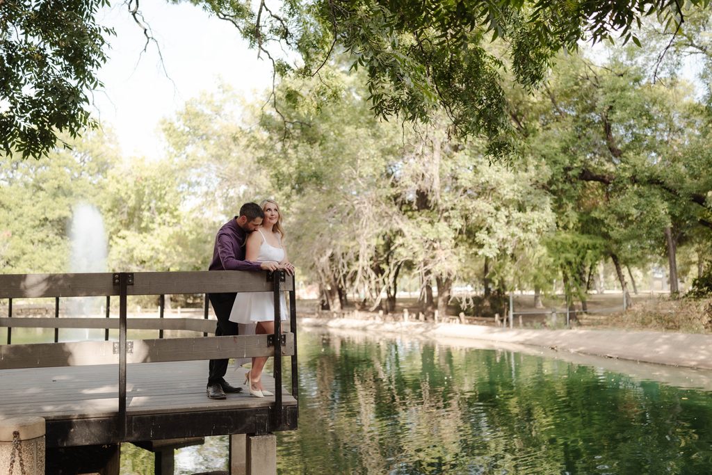 Bride and groom posing on the wood decking at the duck pond at Trinity Park in Fort Worth, TX