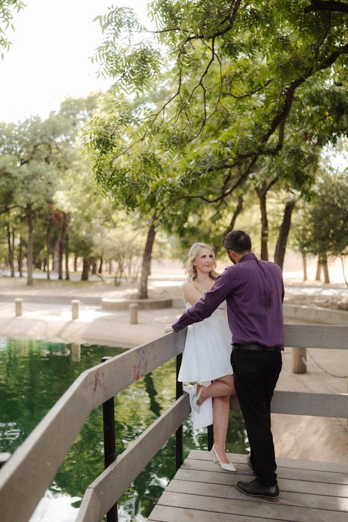 Bride and groom posing on the wood decking at the duck pond at Trinity Park in Fort Worth, TX