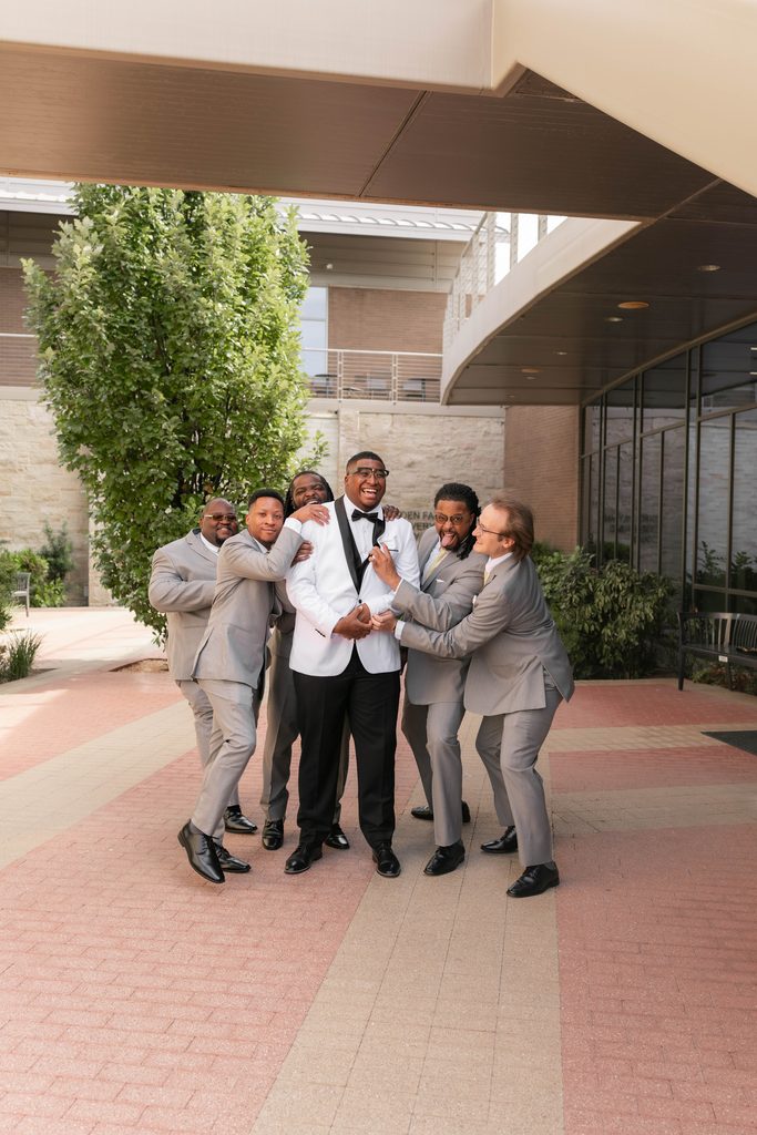 Groom and his groomsmen being silly during their portraits