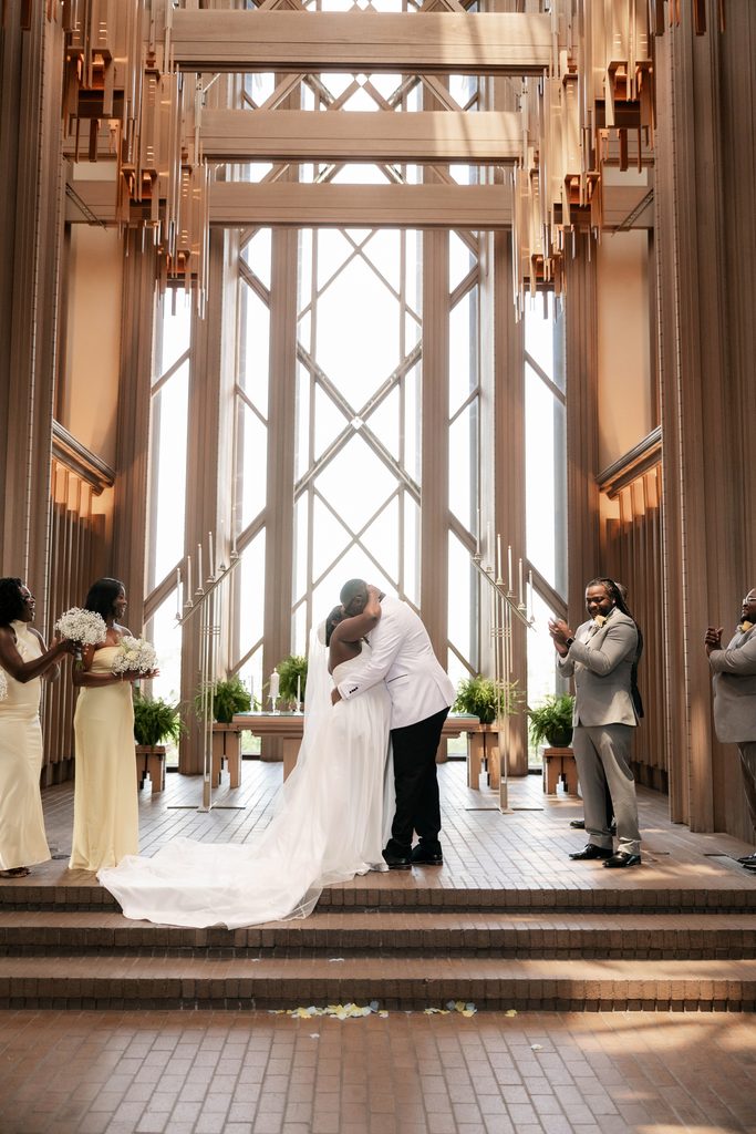 Bride and Groom kissing at the altar during their wedding at Marty Leonard Chapel in Fort Worth, TX
