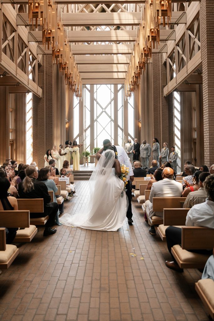 Bride and Groom kissing in the aisle during their wedding at Marty Leonard Chapel in Fort Worth, TX