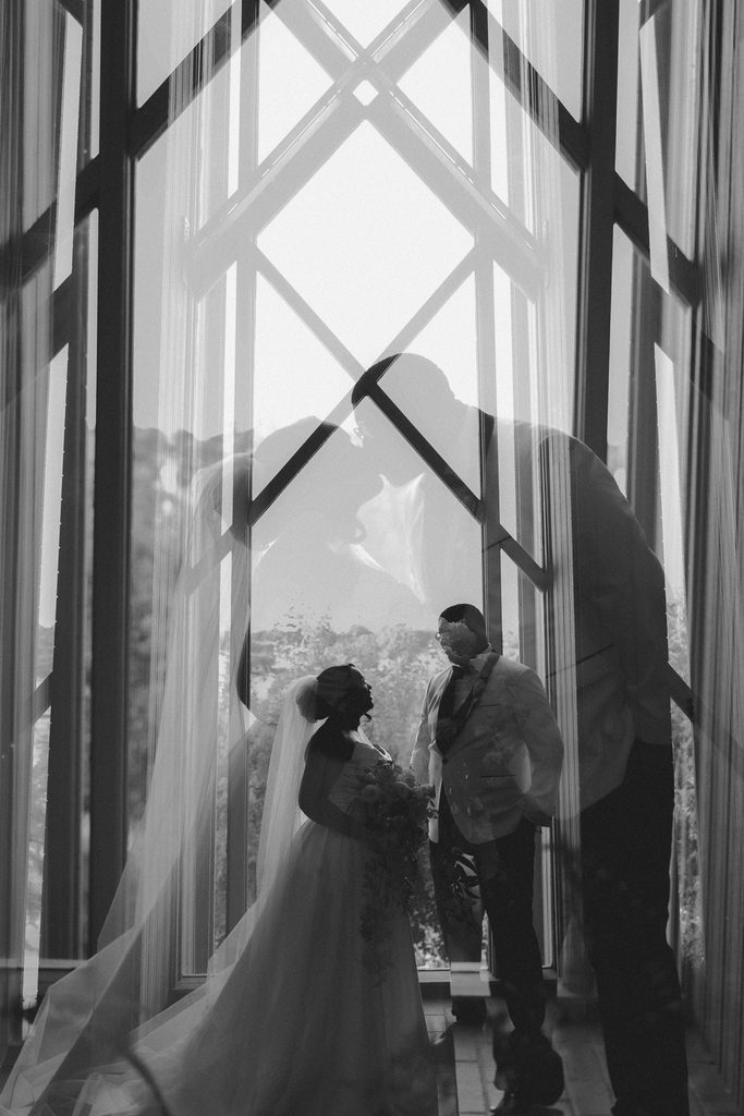 Double exposure shot of Bride and Groom posing in front of a window at Marty Leonard Chapel in Fort Worth, TX