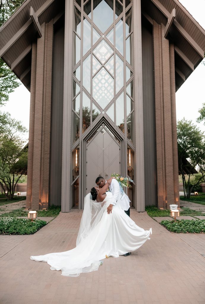 Bride and Groom kissing in front of Marty Leonard Chapel in Fort Worth, TX