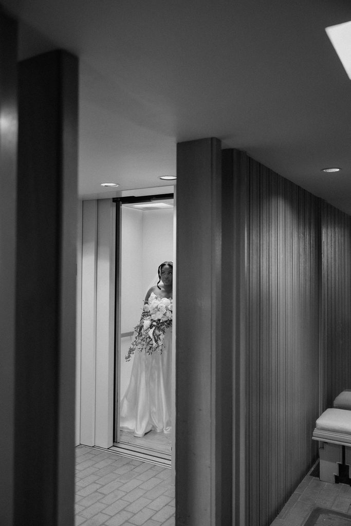 Bride exiting the elevator at the Marty Leonard Chapel before she walks down the aisle