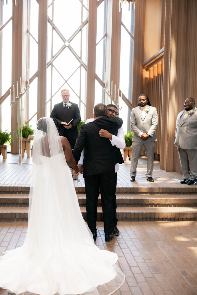 Bride and Groom standing at the altar during their wedding at Marty Leonard Chapel in Fort Worth, TX