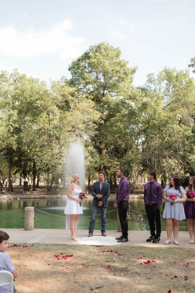 Bride and groom in front of the water fountain at the duckpond during their elopement at Trinity Park in Fort Worth, TX
