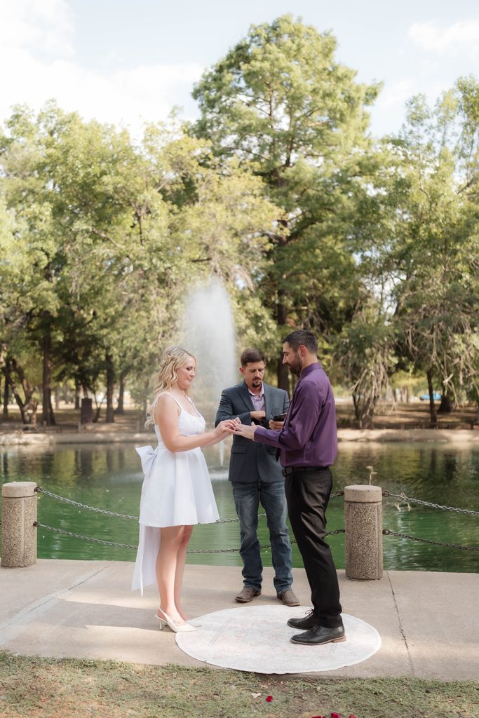 Bride and groom in front of the water fountain at the duckpond during their elopement at Trinity Park in Fort Worth, TX