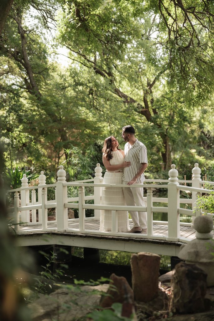 Man and woman cuddling at Chandor Gardens, Weatherford, TX during their engagement photo session