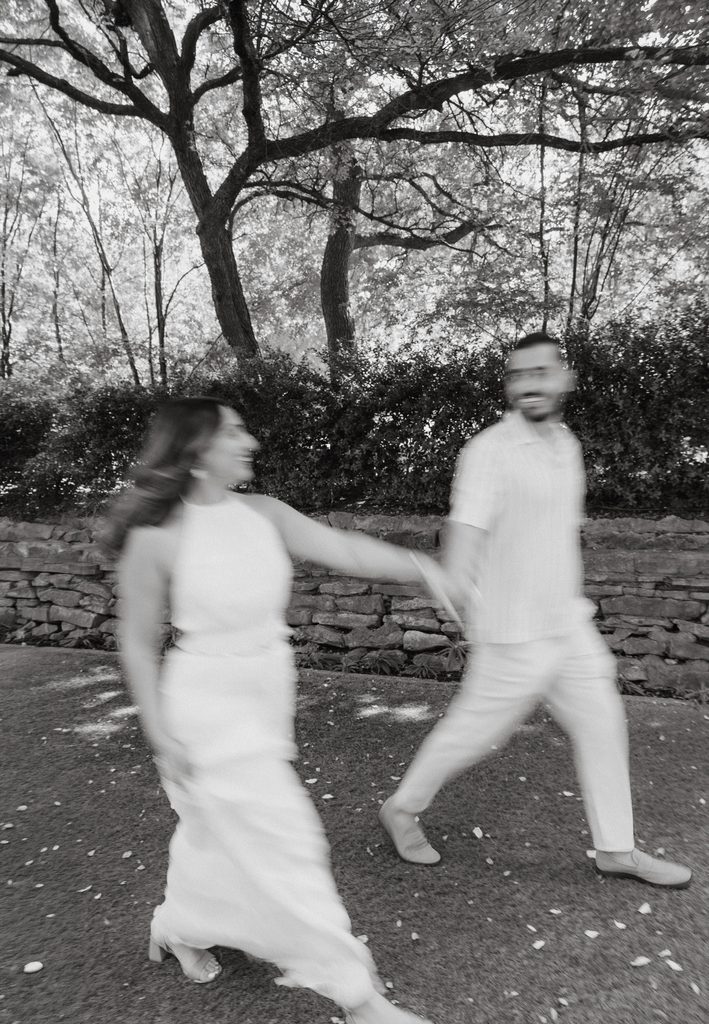 Blurry photo of man and woman frolicking down the green at Chandor Gardens in Weatherford, TX during their engagement session