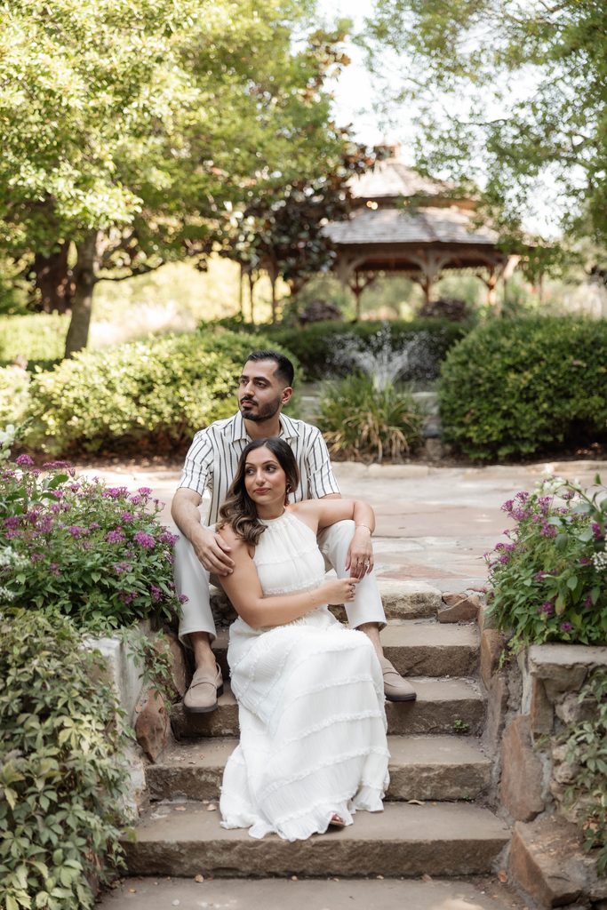 Fiancee's cuddling on steps at Chandor Gardens, Weatherford, TX during a surprise proposal