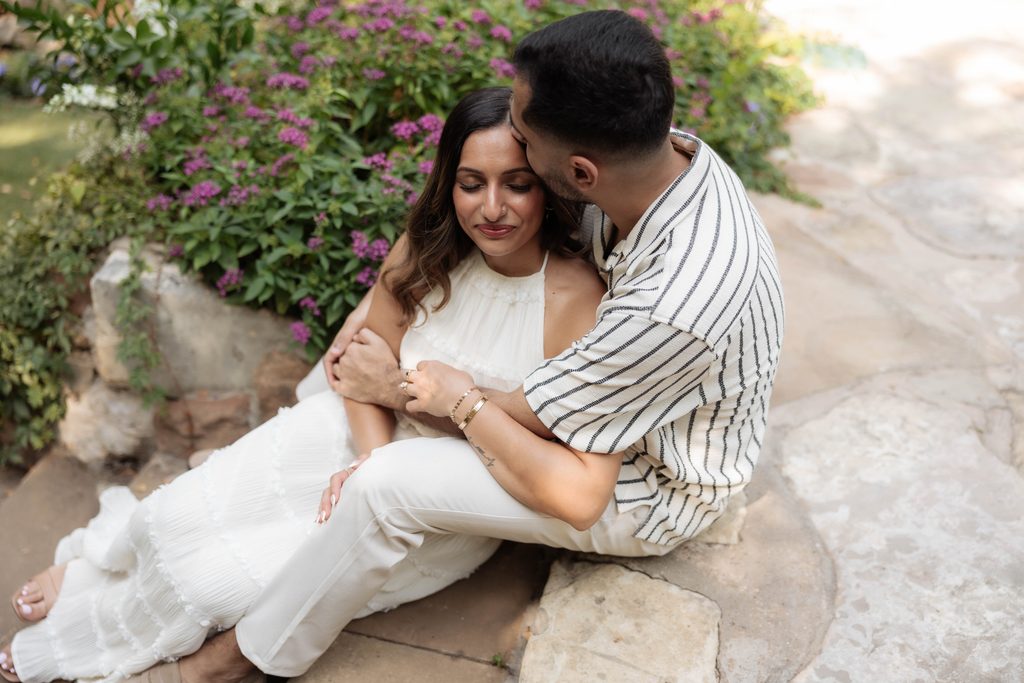 Man and woman kissing and cuddling at Chandor Gardens, Weatherford, TX during their engagement photo session