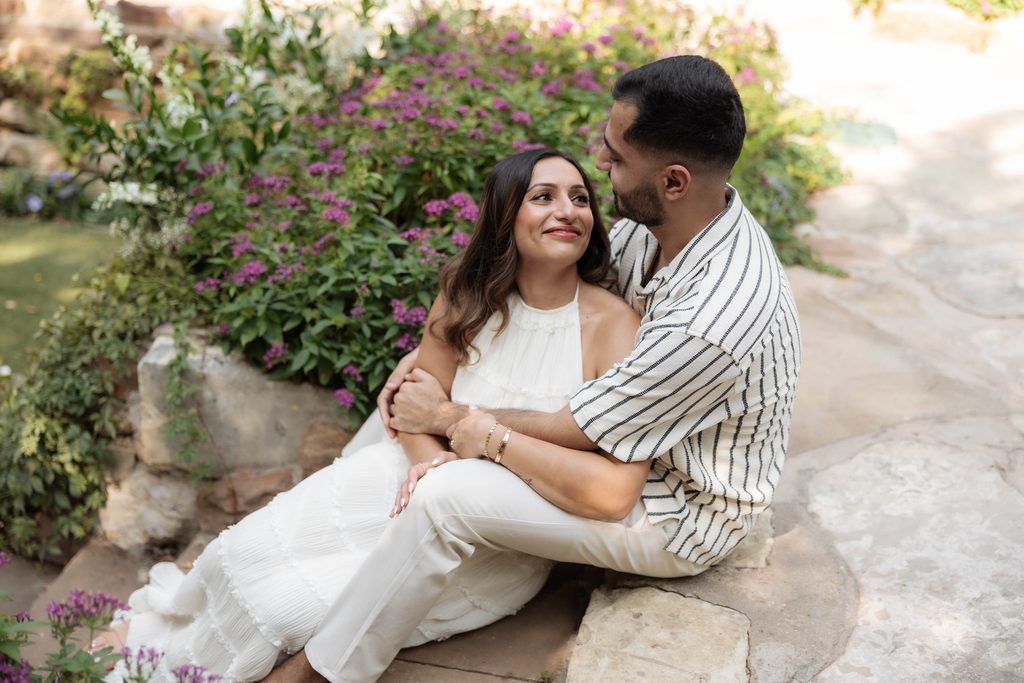 Man and woman kissing and cuddling at Chandor Gardens, Weatherford, TX during their engagement photo session