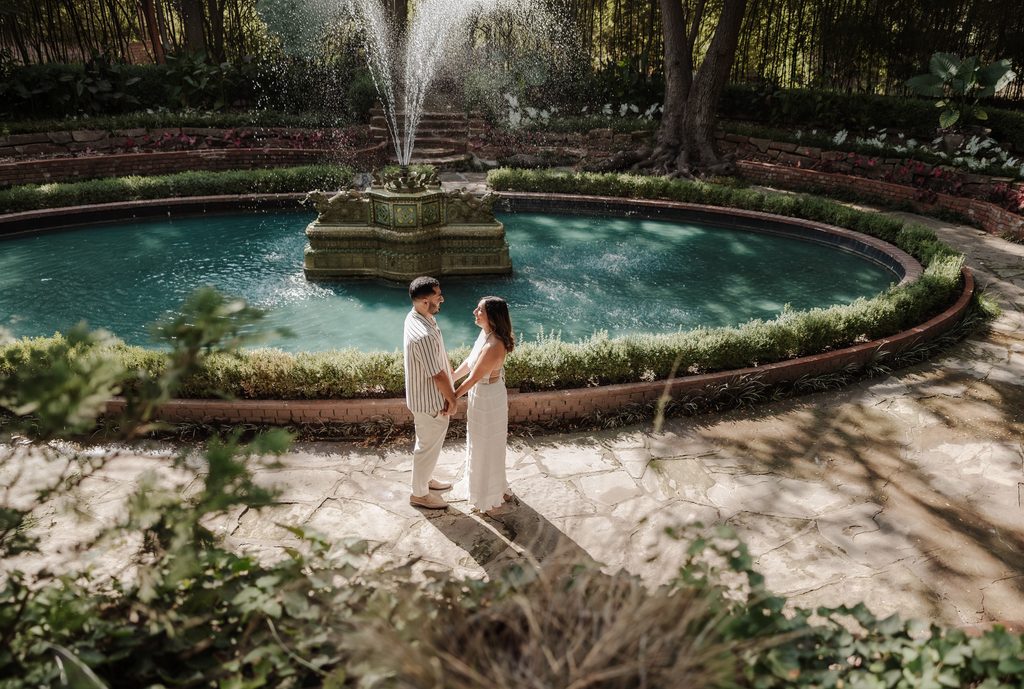 Man and his girlfriend in front of the large fountain in Chandor Gardens, Weatherford, TX during a surprise proposal