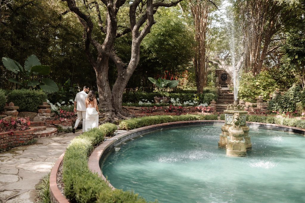 Man and woman walking around the large water fountain 