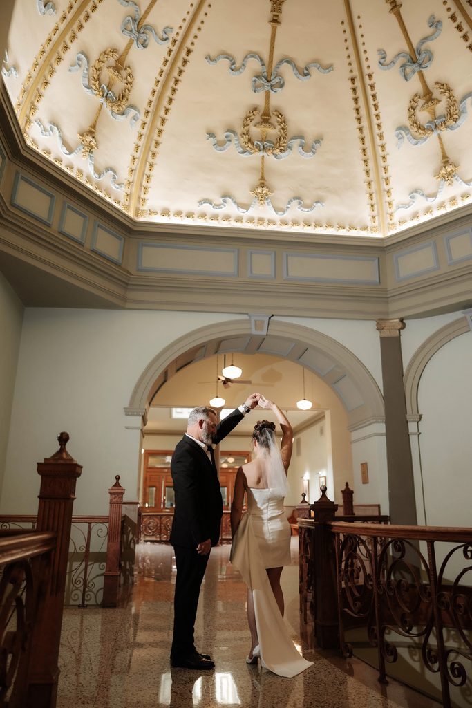 Bride + Groom dancing under the dome at the Tarrant County Courthouse during their adventure elopement in Fort Worth